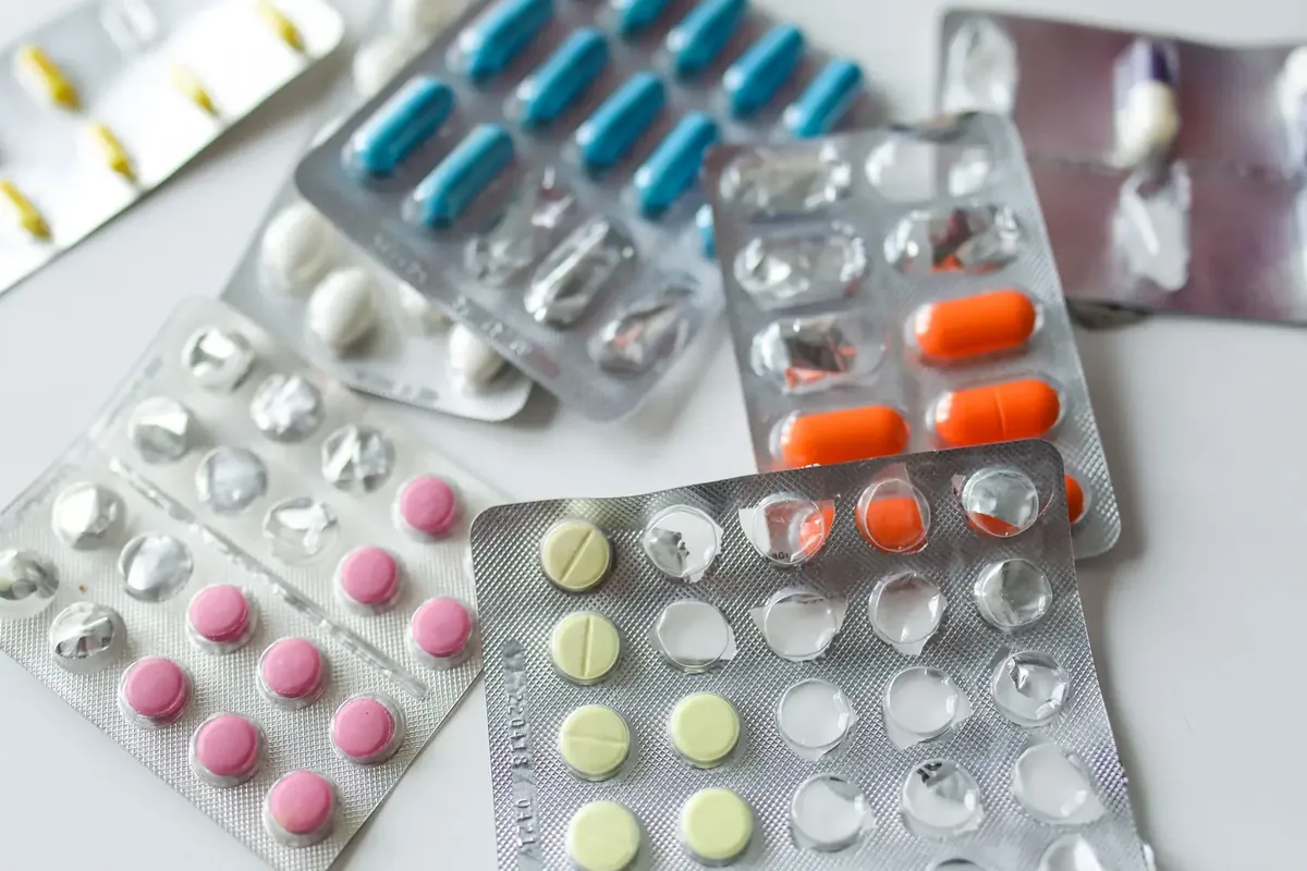 Blister packs of tablets and capsules on a white surface