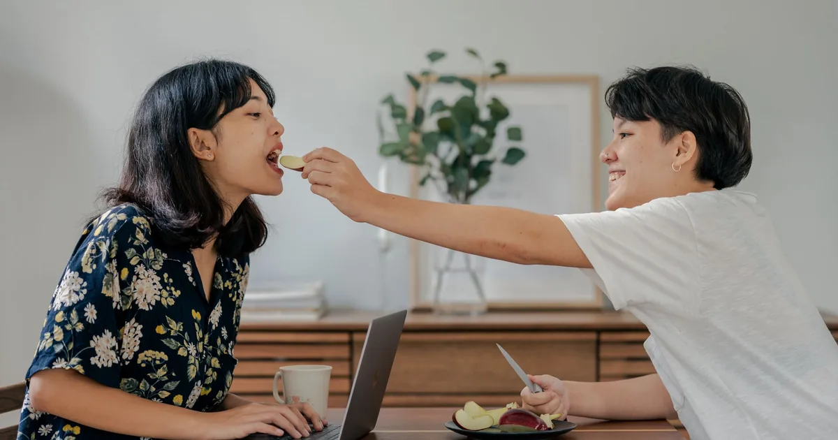 A happy Asian couple laughing and sharing breakfast at home