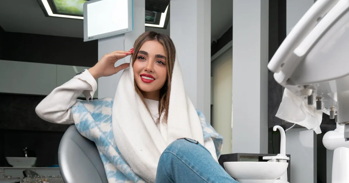 A relaxed, smiling woman sitting comfortably in a dental chair