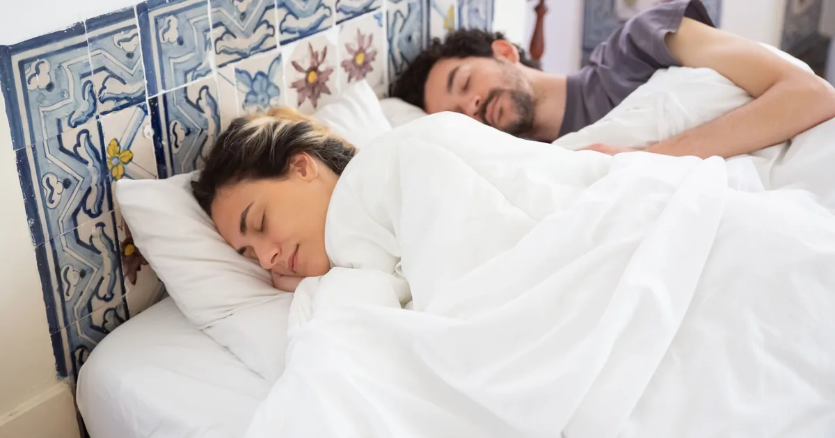 A couple sleeping peacefully in a cozy bedroom