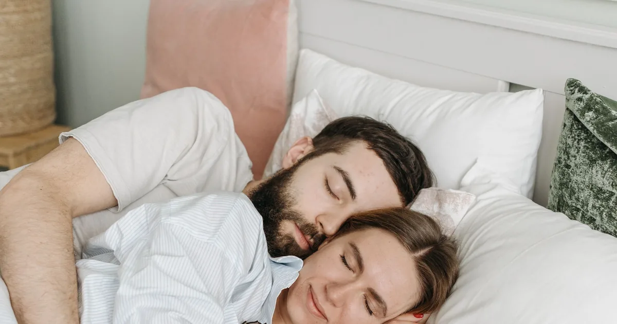 A couple sleeping peacefully together in a bright bedroom