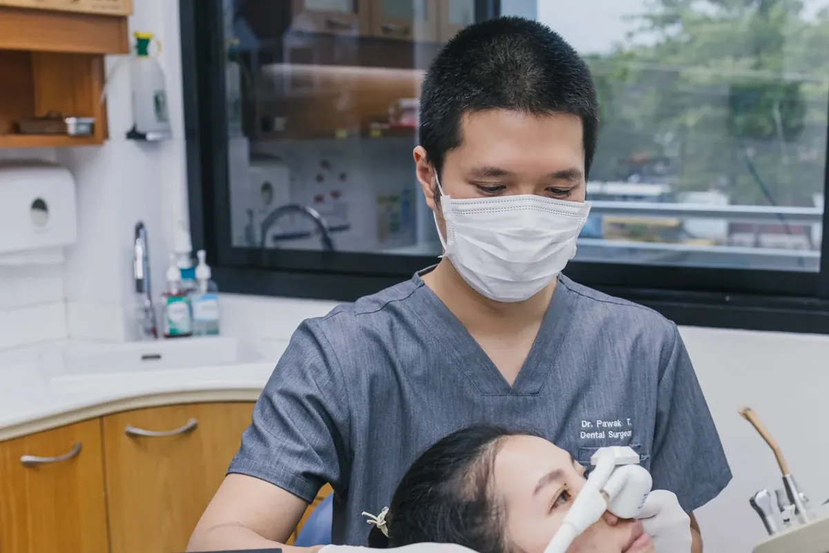 A dentist at Kitcha Dental Clinic fitting an inhaled sedation nose mask for a relaxed patient
