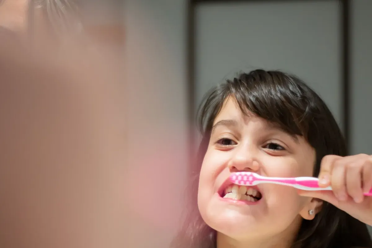 A young girl brushing her teeth at home